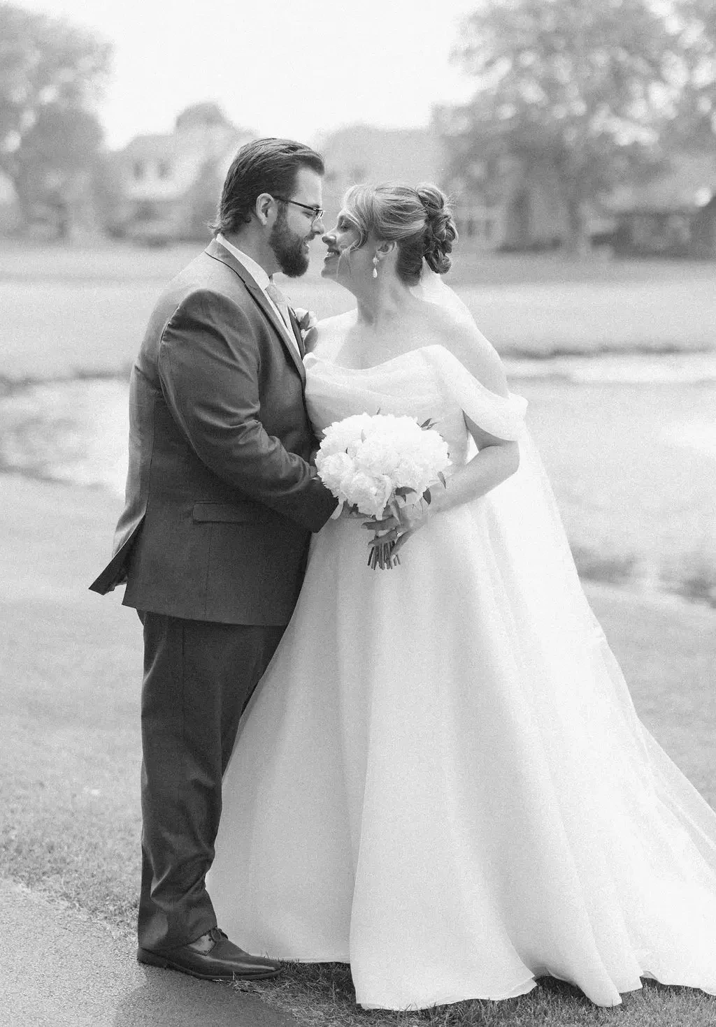 image shows a husband and wife smiling at each other on their wedding day