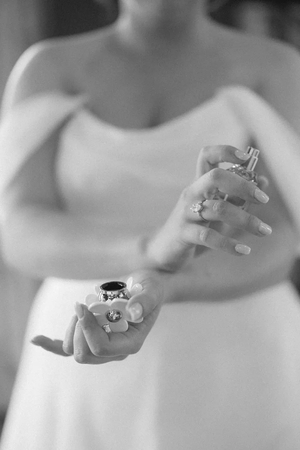 image shows a bride spraying perfume on her wrists on her wedding day