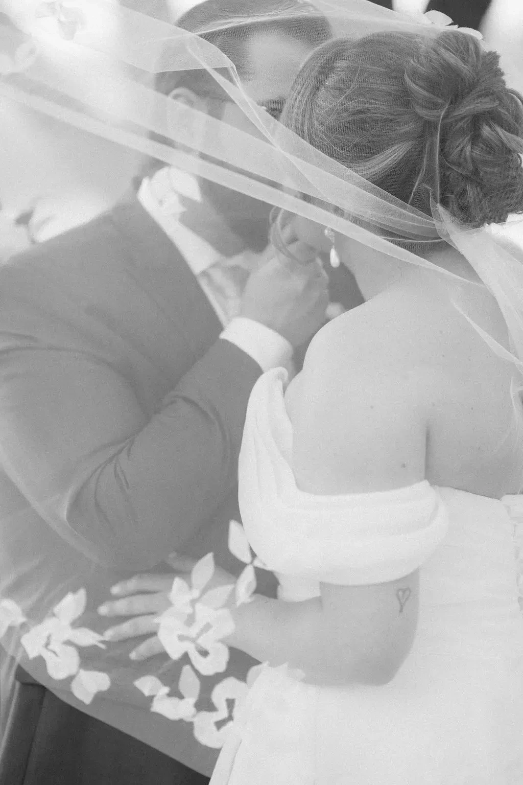image shows a husband and wife kissing on their wedding day
