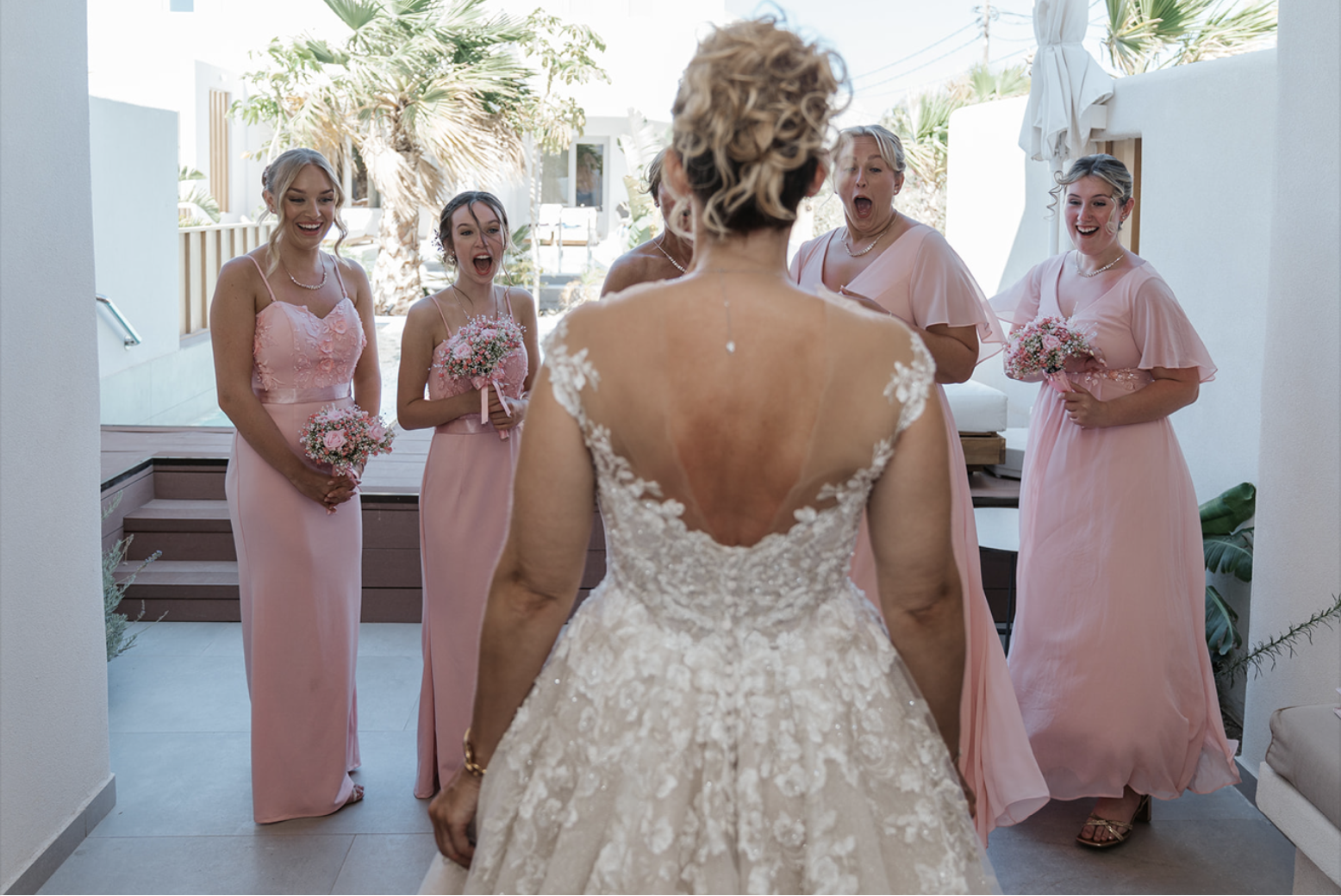 real bride joanne is wearing her wedding dress and showing her bridesmaids on her wedding day