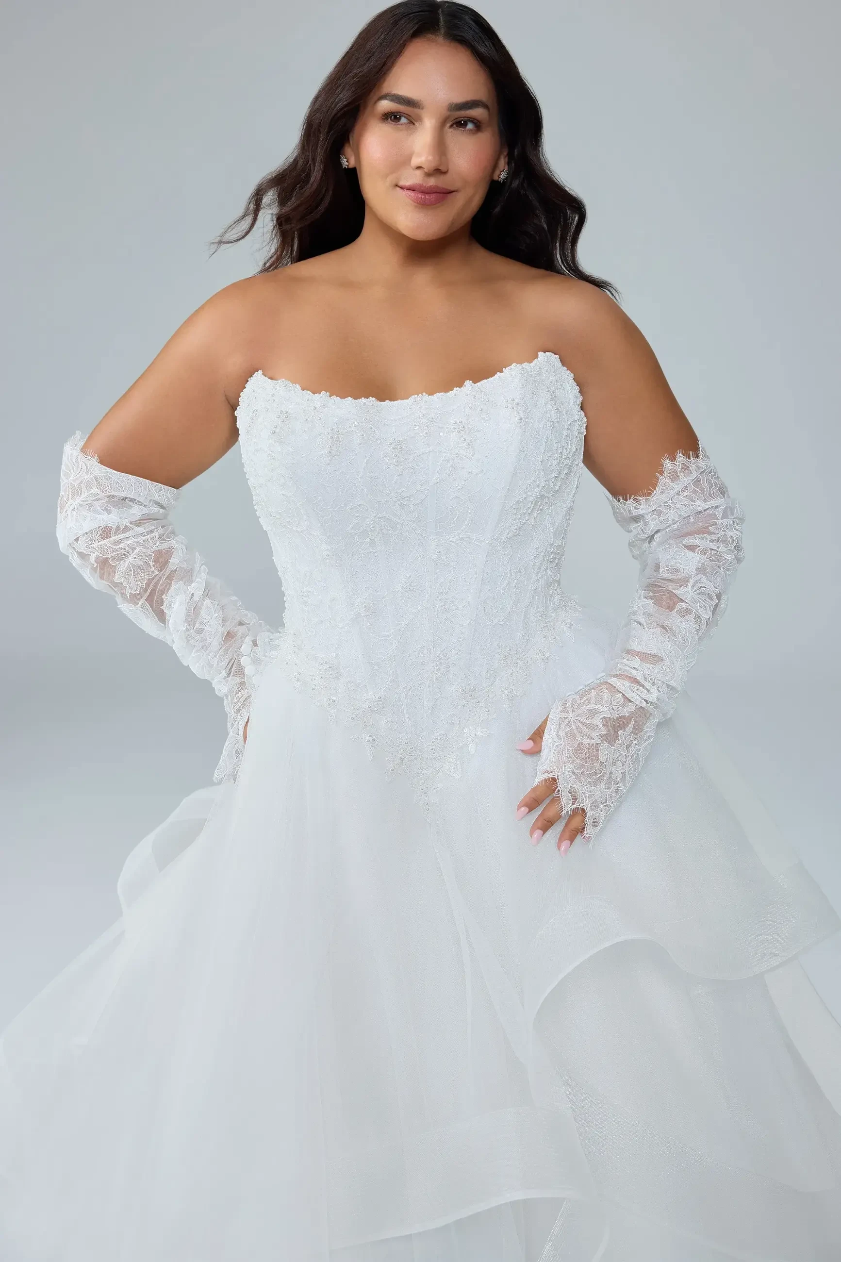 model is wearing a strapless bridal gown with detachable sleeves