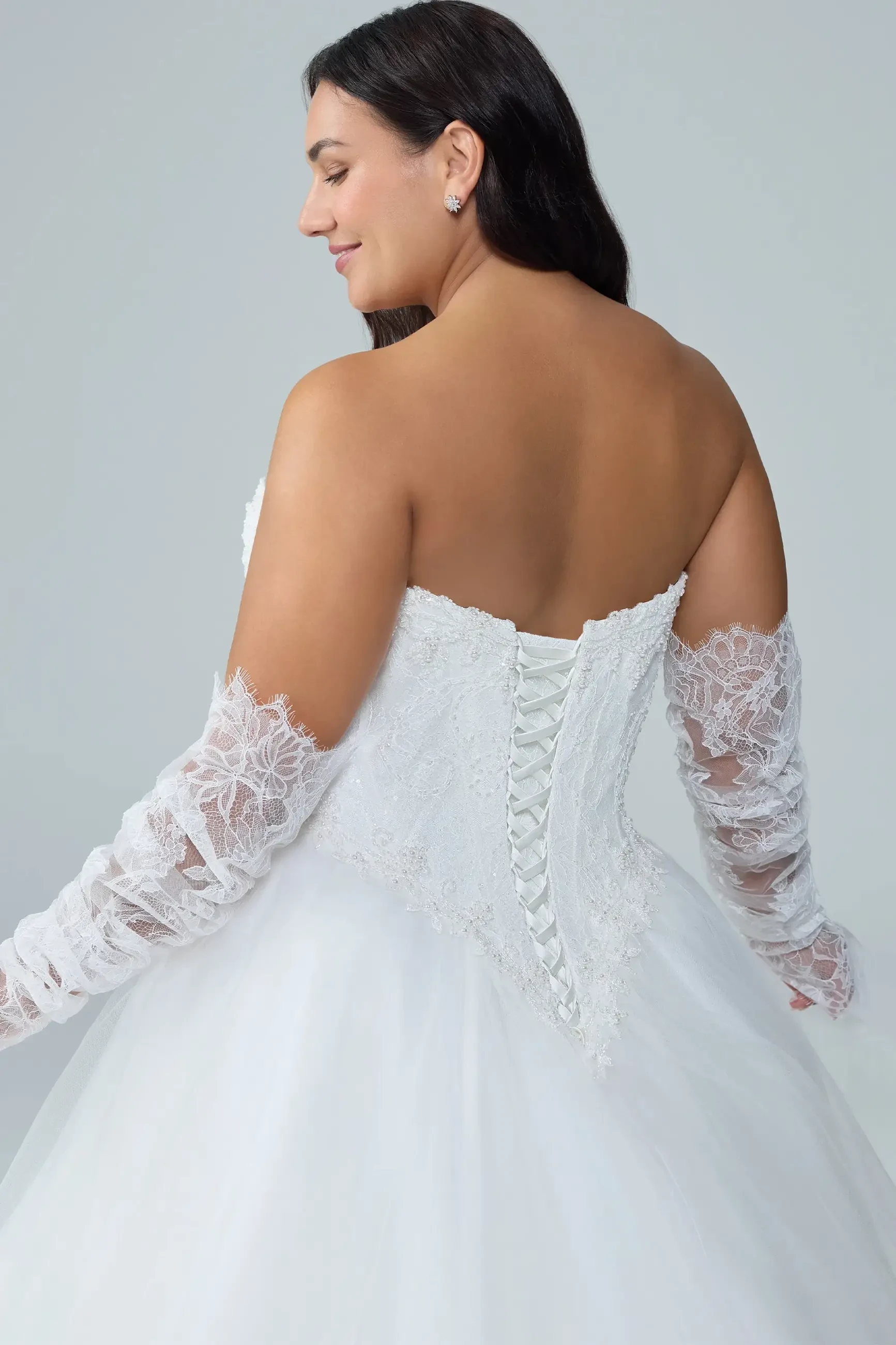 model is wearing a strapless bridal gown with detachable sleeves