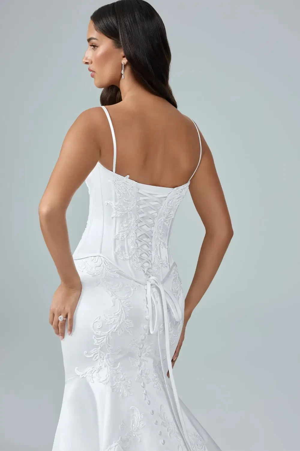 model is wearing an open back sleeveless bridal gown